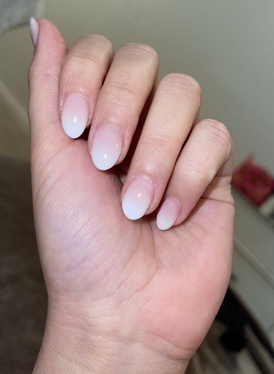 Short almond nails in a pink to white ombre